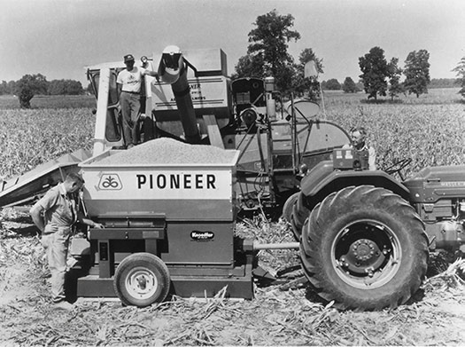 Pioneer agronomy photos - black and white - older tractor operating in field