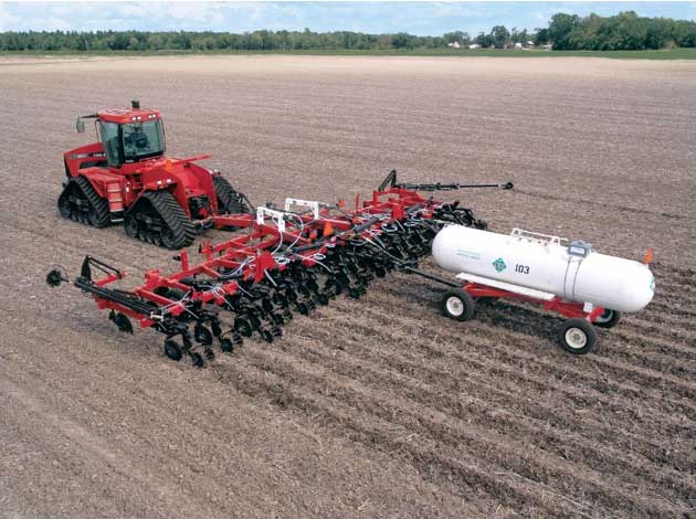 Fertilizer application field operation - red tractor.