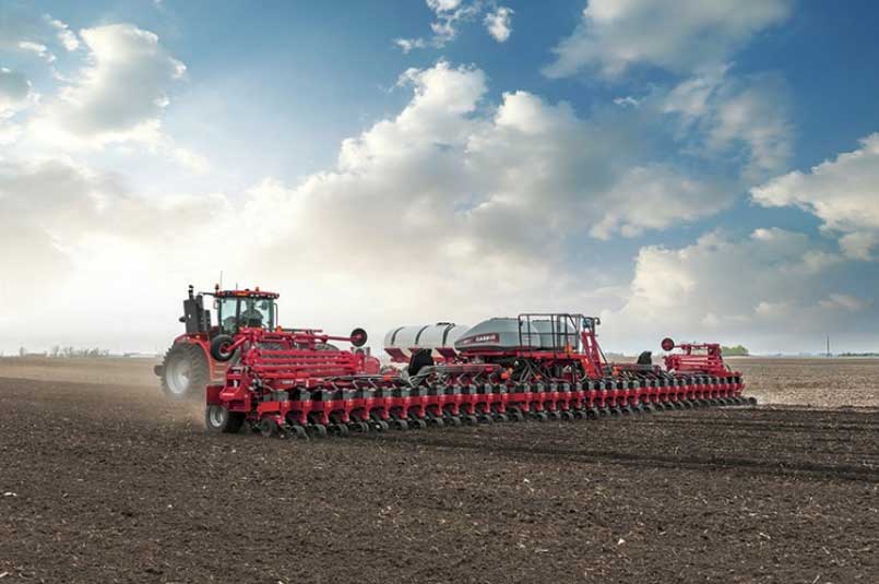 Photo - red corn planter operating in field.