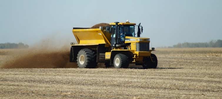 Photo - Fertilizer buggy spreading poultry manure following soybean harvest.