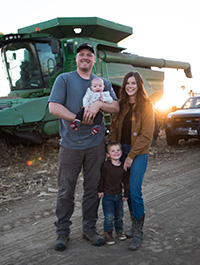 Photo - family standing by harvester in field