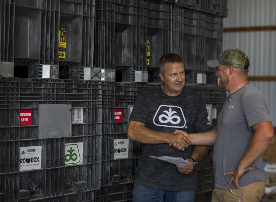 Pioneer rep and grower shaking hands in warehouse
